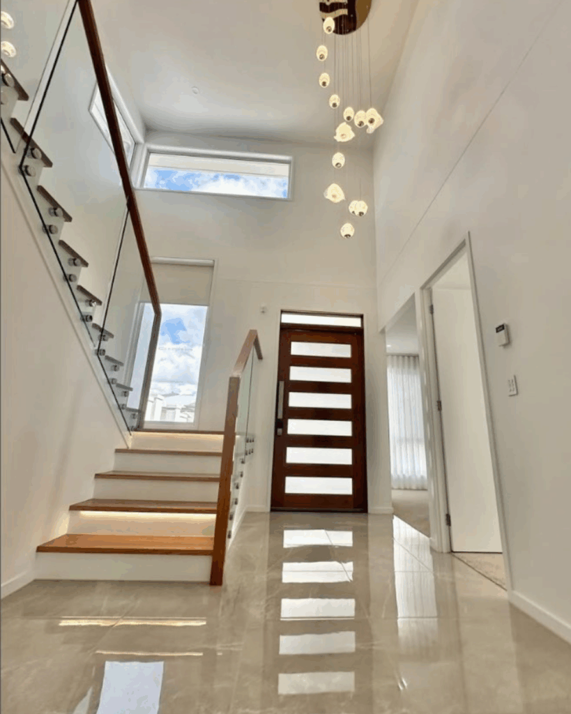 Stair with frameless glass balustrade and front door