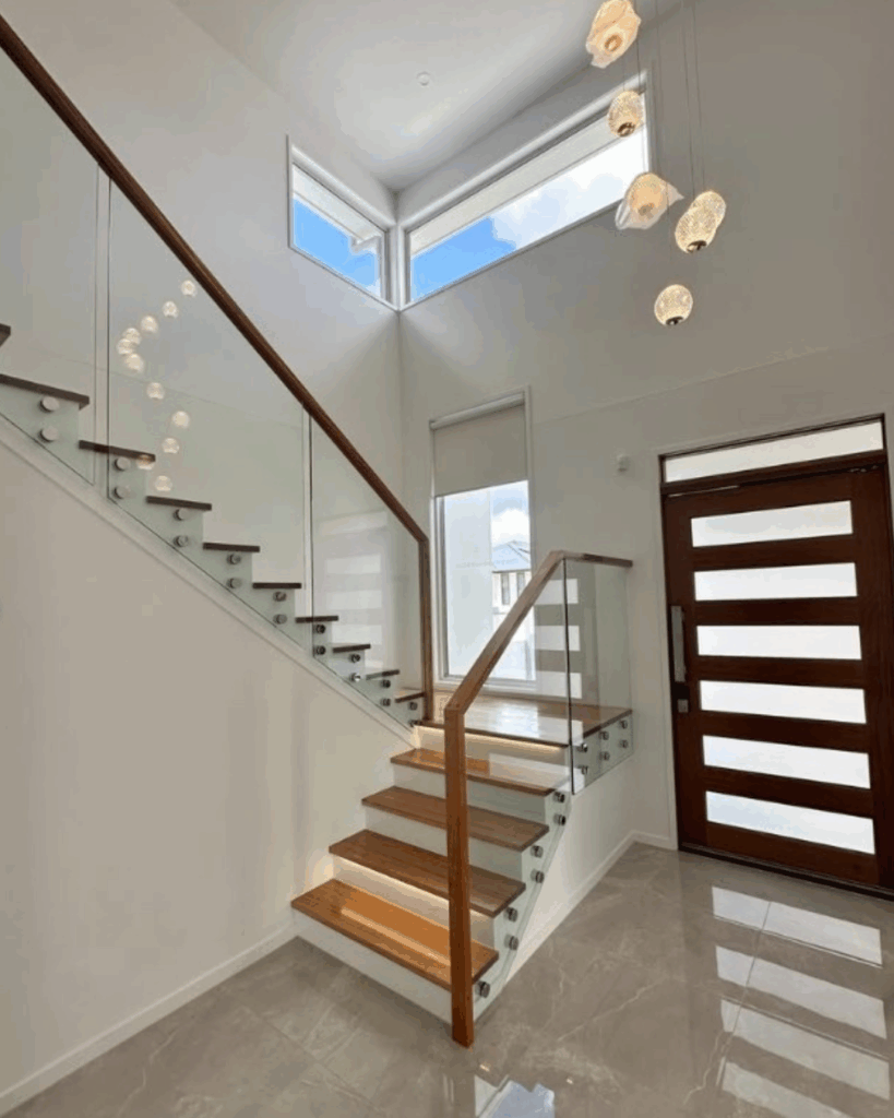 Stair with frameless glass balustrade and front door