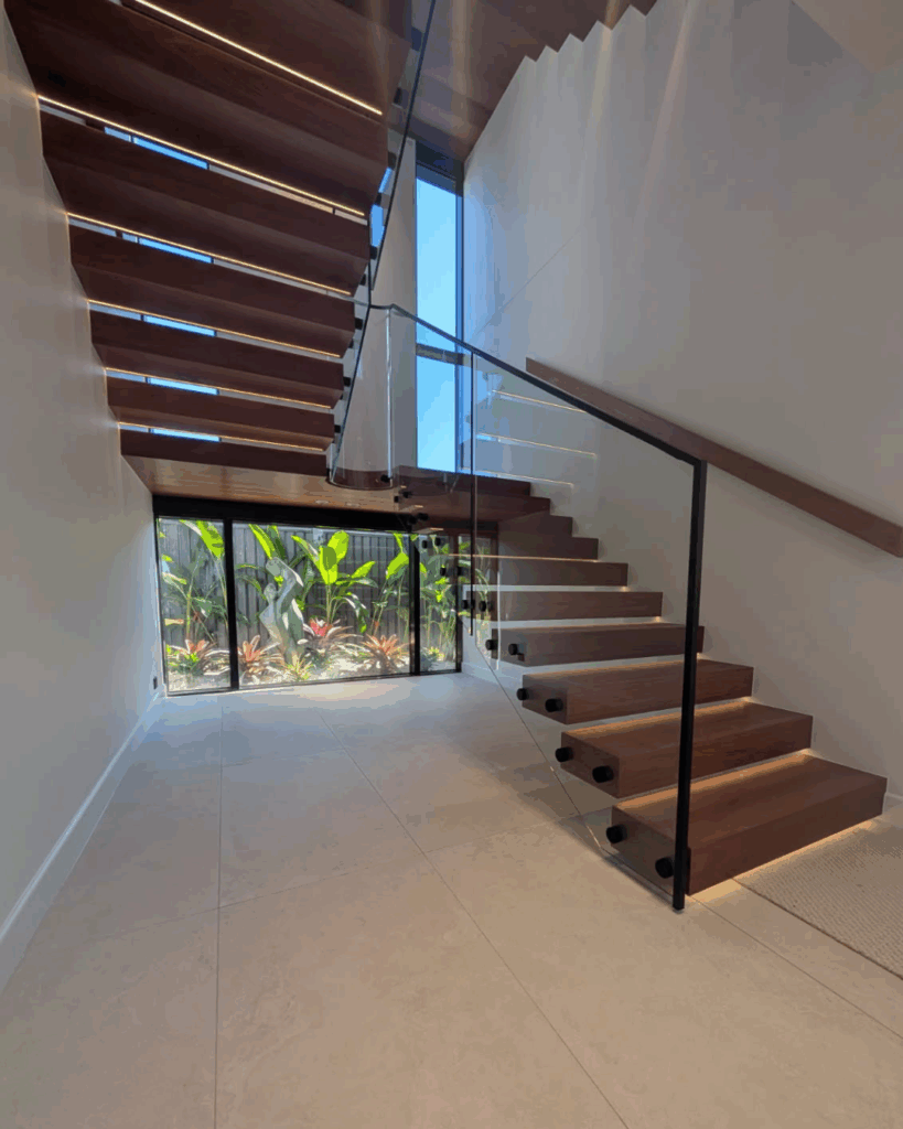 Open cantelevered stair with curved frameless glass balustrade