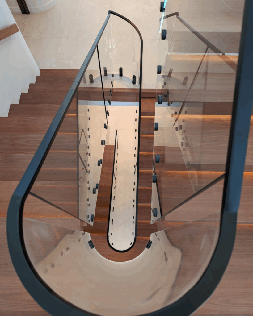 Open cantelevered stair with curved frameless glass balustrade
