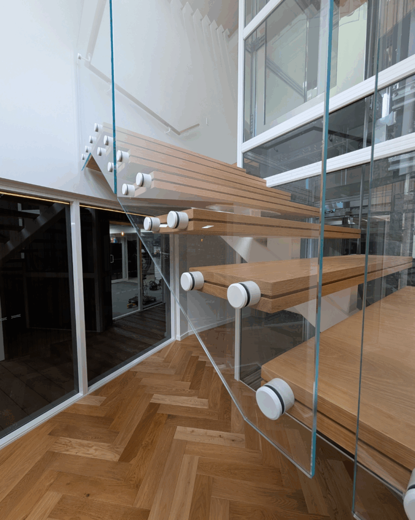 Centre mono steel stringer stair with American Oak treads, frameless glass balustrade and timber wall rail