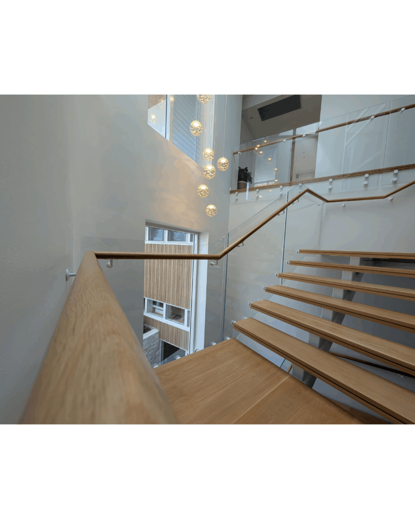 Centre mono steel stringer stair with American Oak treads, frameless glass balustrade and timber wall rail