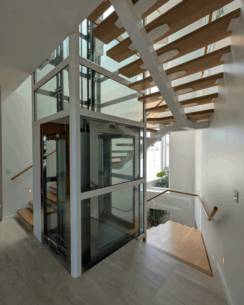 Centre mono steel stringer stair with American Oak treads, frameless glass balustrade and timber wall rail