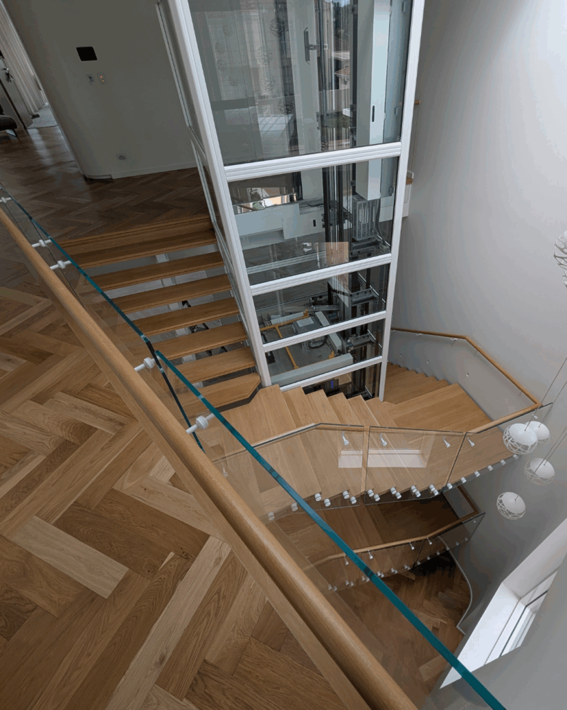 Centre mono steel stringer stair with American Oak treads, frameless glass balustrade and timber wall rail