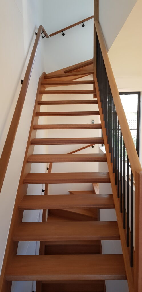 Open stairs with winders, a wall rail, and powdercoated balustrade with a timber frame