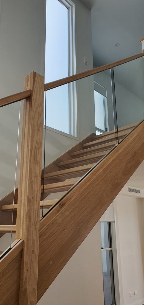 Open stair with framed glass balustrade viewed from the side of the stair