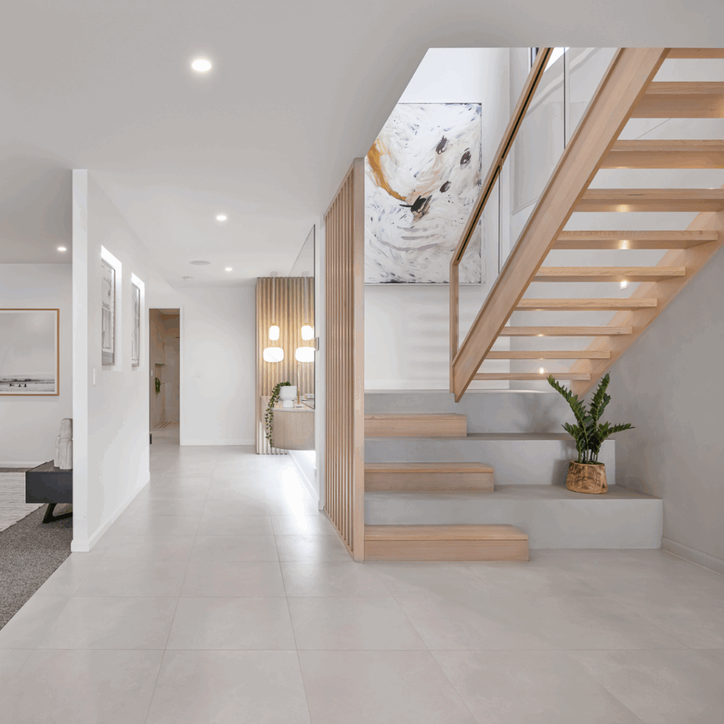 Stadium stair lower flight with open upper flight and glass balustrade. A pot plant sits on the lower flight