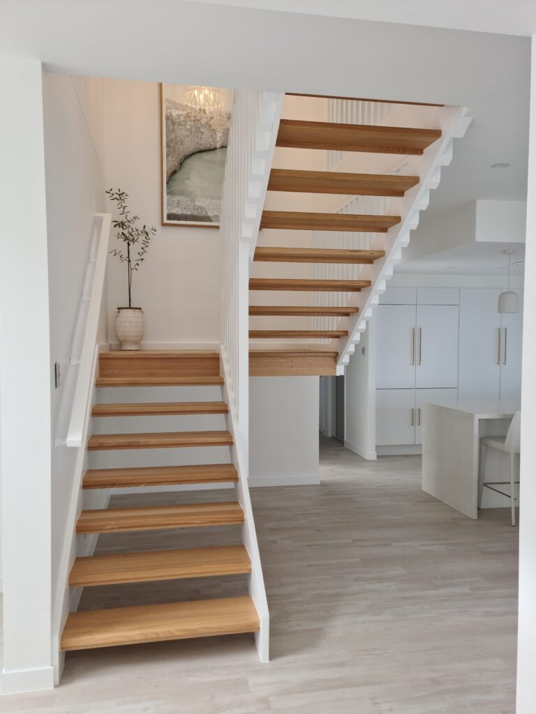 Front on view of open staircase with timber screen. A potplant sits on the stairs