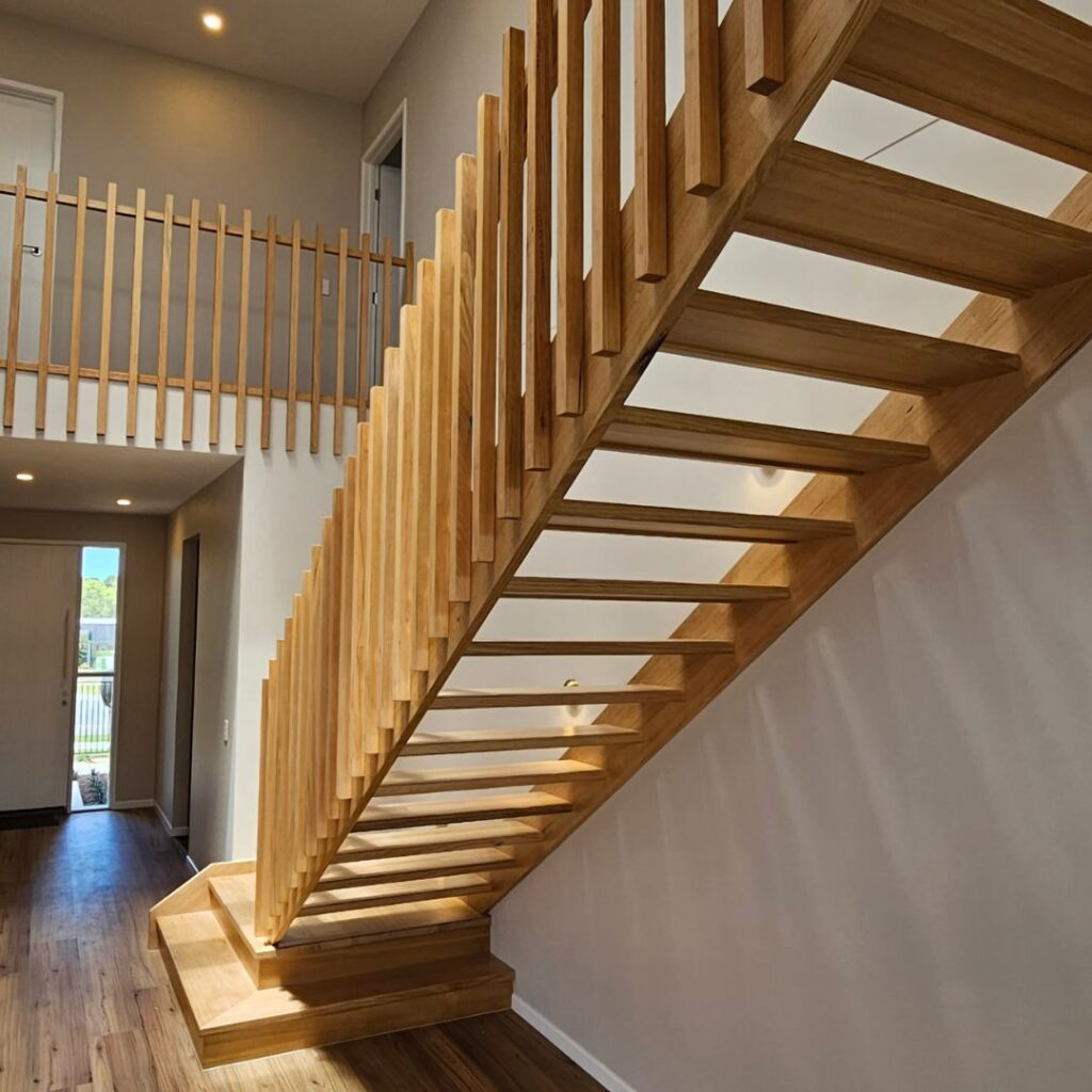 Open timber stair with timber balustrade viewed from the back of the stair