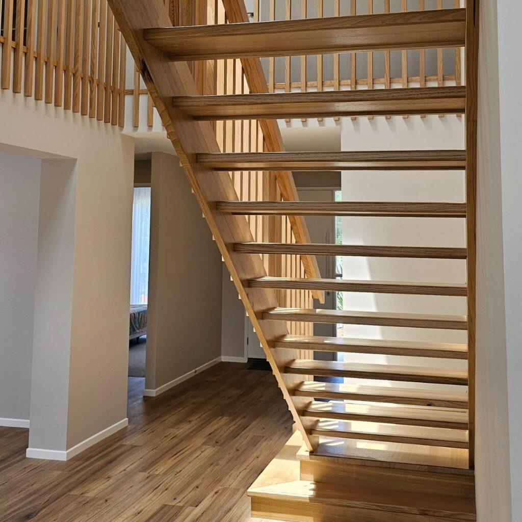 Open timber stair with timber balustrade viewed from the back of the stair