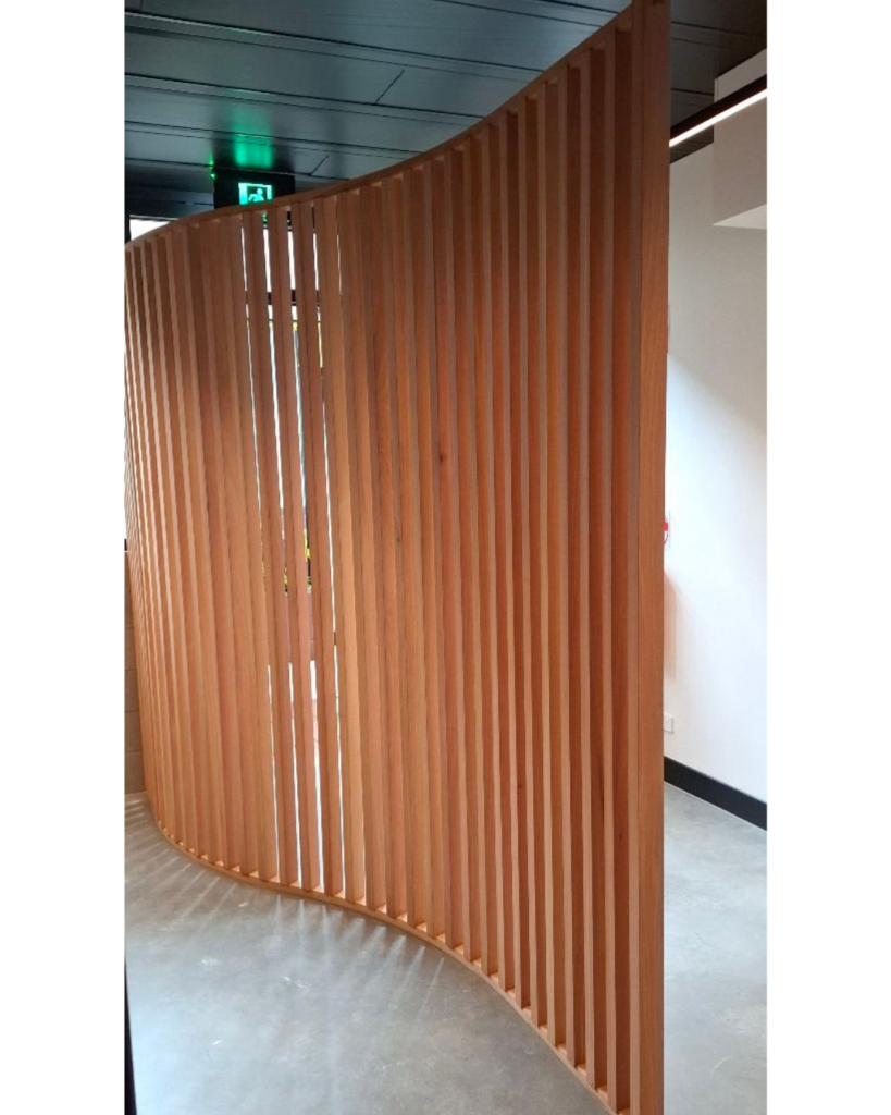 Curved timber screen made from Melunak timber in a partially finished commercial tenancy