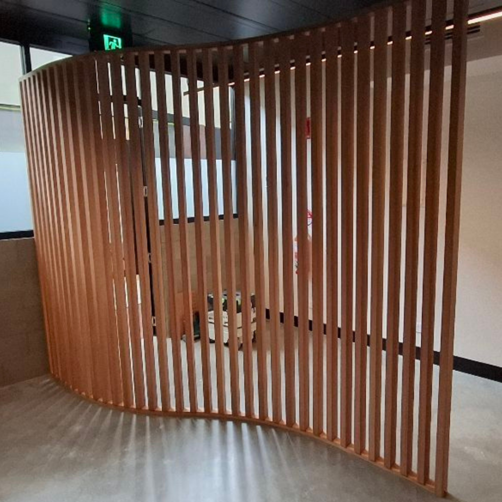 Curved timber screen made from Melunak timber in a partially finished commercial tenancy