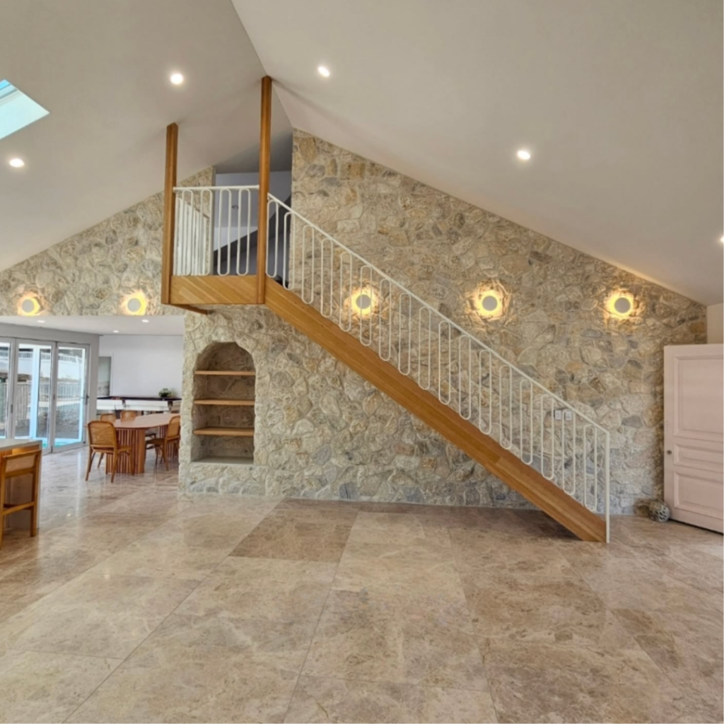 Side-view of stair hanging from the ceiling on timber posts made from Victorian Ash timber and featuring white powder coated balustrade
