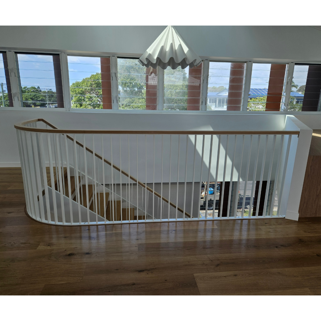 Modern powder coated balustrade and timber top rail to stair void.